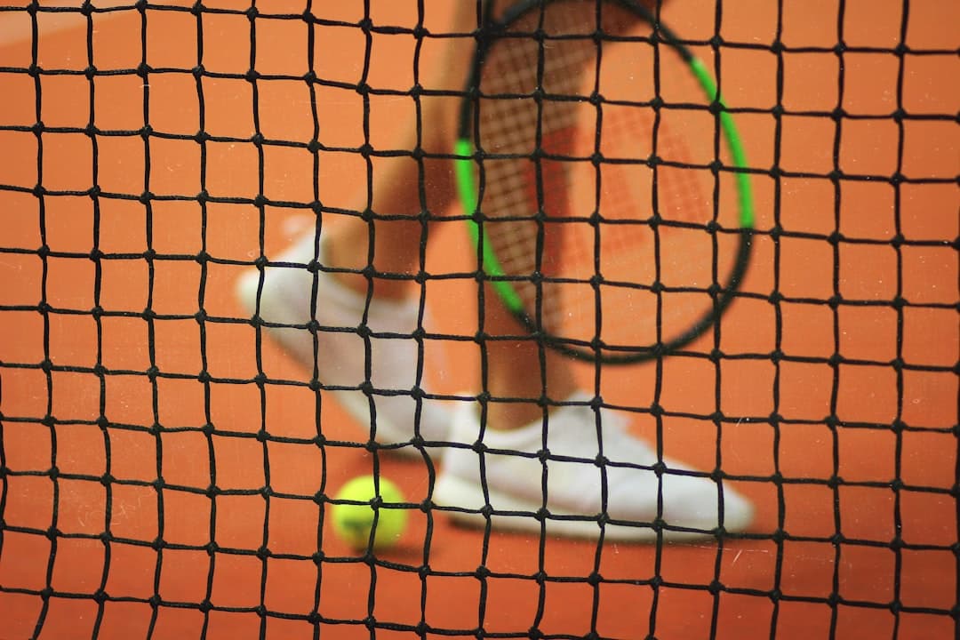 Jogador de tênis segurando raquete Wilson em quadra rápida